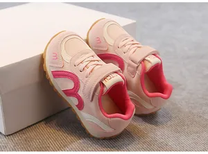 Close-up view of pink breathable mesh kids sneakers leaning against white gift packaging