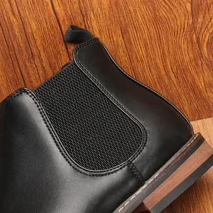 Gros plan d'une bottine Chelsea en cuir noir avec panneau élastique et coutures