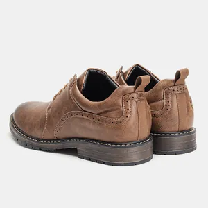 Detailed rear view of brown faux leather men's dress shoes with brogue perforations.
