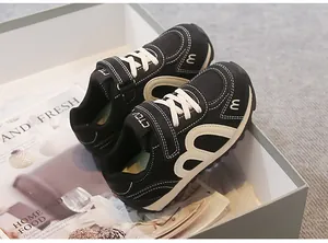 Detailed view of breathable black children's sneakers presented in a stylish white box