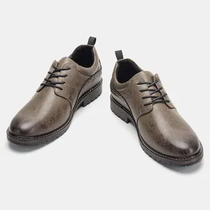 Detail view of brown textured leather Oxford shoes with black laces and brogue details