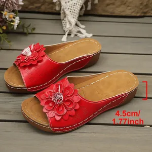 Detalle de sandalias de cuña rojas con flores y altura de tacón de 4,5 cm para mujer
