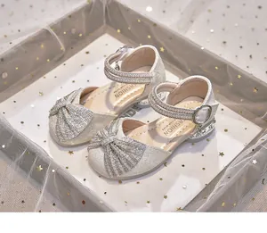 Detailed view of sparkling silver girls' princess shoes with pearl bows.
