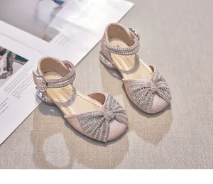 Detailed view of girls glittery princess sandals with elegant pearl bow decoration