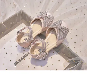 Detailed view of pink glittery girls' sandals with pearl bows and star background