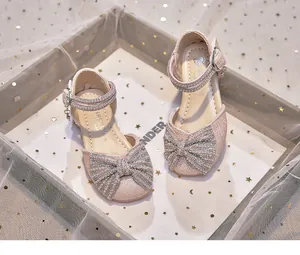 Macro view of pink glittery girls princess sandals featuring a pearl-encrusted bow