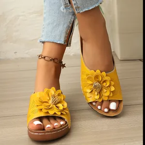 Elegantes chanclas de cuña amarillas para mujer con un detalle de flor grande decorativa.