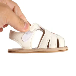 Close-up of soft cream baby girl sandal featuring an adjustable hook-and-loop fastener strap