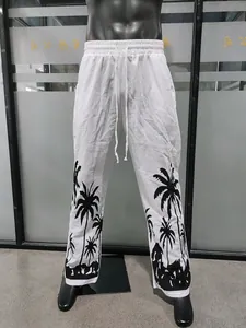 Detail of white linen trousers with black palm tree Hawaiian print and drawstring waist