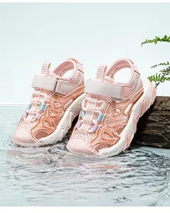 Macro view of pink children's breathable mesh sandals in a dynamic water splash scene