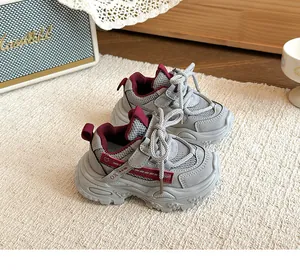 Detailansicht grauer und roter atmungsaktiver klobiger Sneaker mit weichen Sohlen für Kinder
