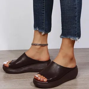 Detailed view of women's dark brown peep-toe wedge sandals with thick platform soles