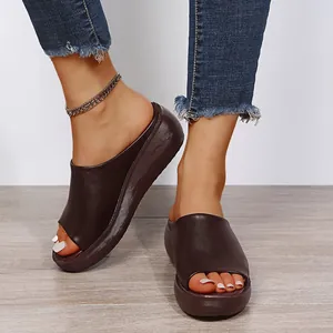 Dark brown women's wedge platform slides with peep-toe design on wooden floor background