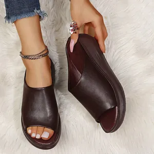 Detailed view of brown platform wedge slippers for women on white faux fur rug.