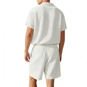 Back view of a minimalist men's white waffle knit short sleeve polo shirt and shorts set.