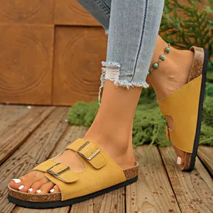 Yellow suede double buckle sandals on a wooden deck with a summer vibe