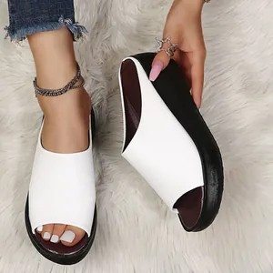 Close-up of stylish white platform wedge sandals on a soft faux fur rug