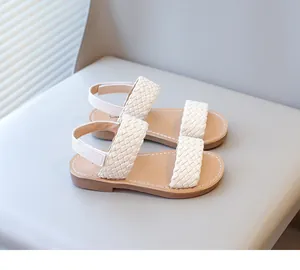 Detail view of white woven straps on stylish girls' summer beach sandals.