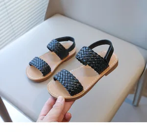 Detailed view of black woven straps on stylish girls' summer beach sandals.