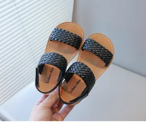 Close-up of black woven straps and brand logo on stylish kids' summer sandals.