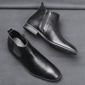Classic black leather men's Chelsea boots with side zipper on grey textured background