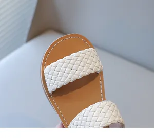 Close-up of white woven straps on child's stylish summer sandal with tan sole