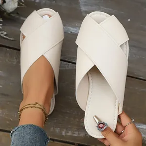 Detailed macro view showing texture and design of cream cross-strap flat slides