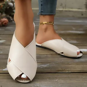 Close-up of cream peep-toe flat mules with textured crossed straps for summer