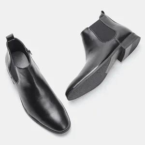 Detailed view of men's black Chelsea boots with elastic sides and textured soles