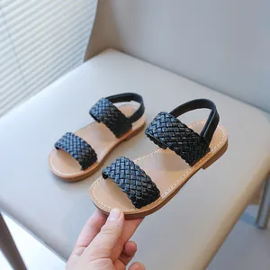 Fashionable black woven strap sandals for girls with a comfortable tan cushioned footbed.