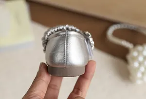 Dettaglio della trama in pelle metallizzata argento e suola morbida per scarpe da bambina