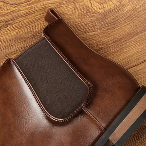 Macro view of brown leather Chelsea boot showing elastic panel and stitching detail