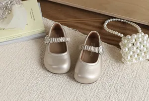 Dettaglio di scarpe da principessa per bambine color oro champagne con fibbia in strass