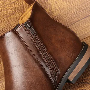 Detailed macro view showing the side zipper on classic brown leather Chelsea boots
