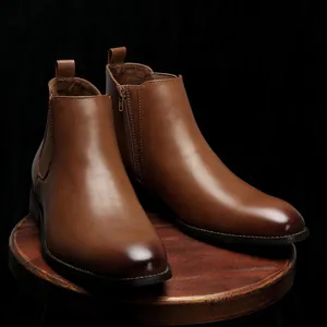 Detail view showing the premium brown leather texture of classic men's Chelsea boots