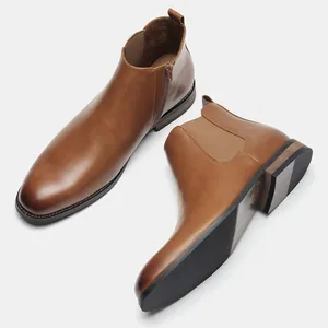 Detailed view of men's classic brown leather Chelsea boots with side zipper and elastic.