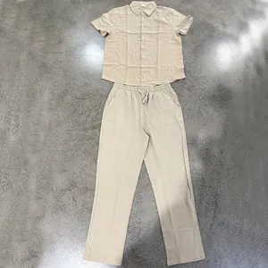 Detailed flat lay of men's linen short sleeve shirt and long trousers in khaki color