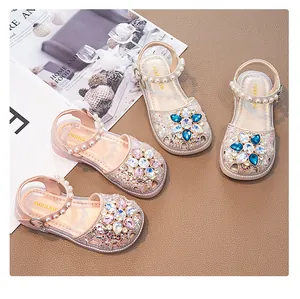 Close-up of girls princess sandals in pink and cream with rhinestone flowers.