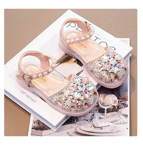 Close-up of pink princess sandals with pearl strap and crystal flower detail