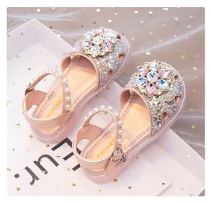 Detailed view of pink sparkly girl's princess sandals with large crystal flower ornament