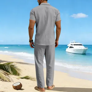 Back view of a man wearing a grey linen shirt and pants set on a tropical beach