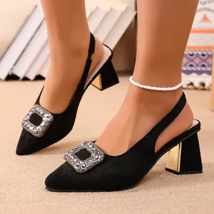 Gros plan de sandales slingback en daim noir avec talon bloc et boucle en strass