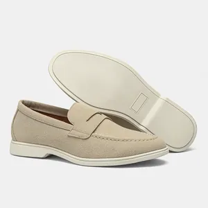 Vista dettagliata dei mocassini in pelle scamosciata beige da uomo con suola in gomma bianca