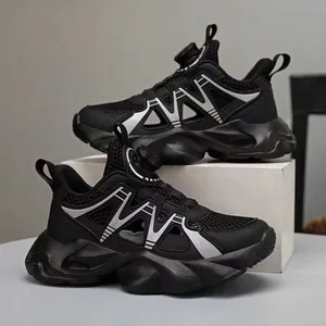 Chaussures de sport noires en maille respirante pour garçons avec boucle rotative.