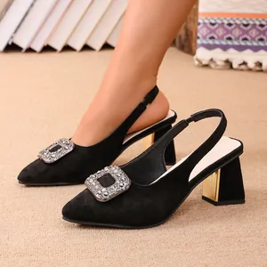 Gros plan d'escarpins slingback en daim noir avec boucle en strass et talon doré