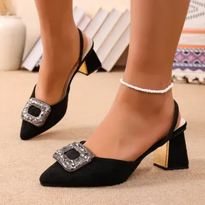 Gros plan de sandales en daim noir à talons épais avec boucle en strass brillante
