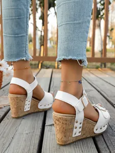 Elegant white platform wedge sandals featuring chic rivet details and buckle strap.