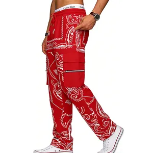 Detailed view of men's red paisley cargo pants featuring multi-pockets and reflective straps