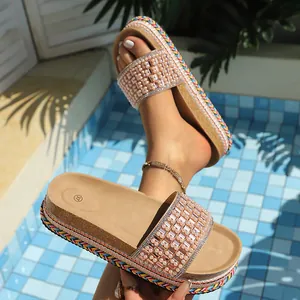 Primer plano de sandalias de plataforma beige con adornos de perlas y pedrería fina