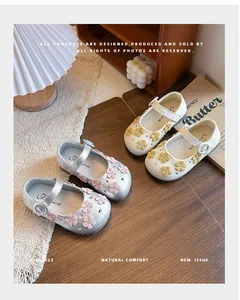 Close-up of girls' floral Mary Jane shoes in silver and white colors style.